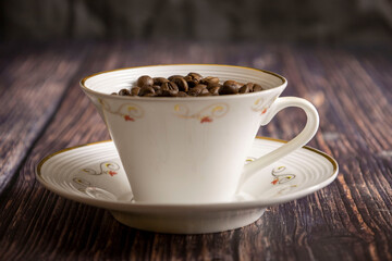 A cup with coffee beans on a dark background.