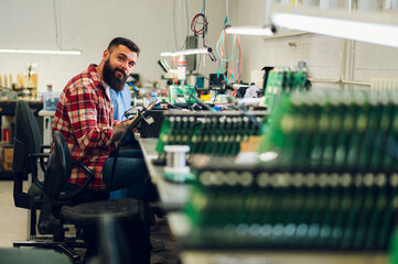 Electronics engineer working in a workshop with tin soldering parts