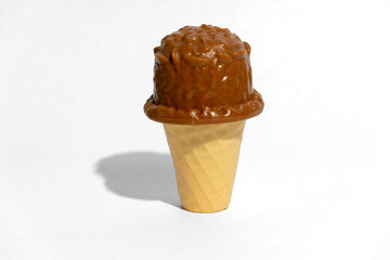 Toy chocolate ice cream in a cone on white background