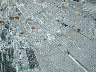 Damaged broken glass. Act of vandalism or war conflict. Grey color.