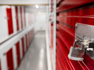 Long row of red color doors of self storage facility. Service to keep safe extra belongings....