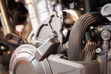 Motorcycle fuel pipes. Closeup of 2 black rubber oil hoses wrapped in a braided heat resistant coil for security with copy space and focus.