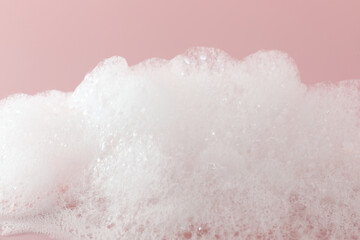 Fluffy bath foam on pink background, closeup - Powered by Adobe