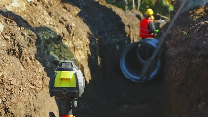 Workers on the construction site laying new sewer pipes. Installation of waste water pipes at the construction site