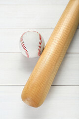 Baseball bat and ball on white wooden table, above view. Sports equipment