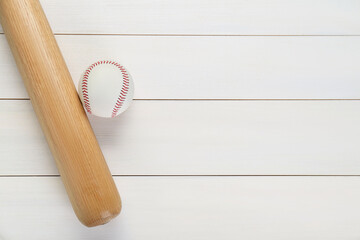 Baseball bat and ball on white wooden table, top view with space for text. Sports equipment