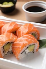 Food delivery. Delicious sushi rolls in plastic container, closeup