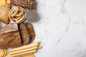 Different gluten free products on white marble table, flat lay. Space for text