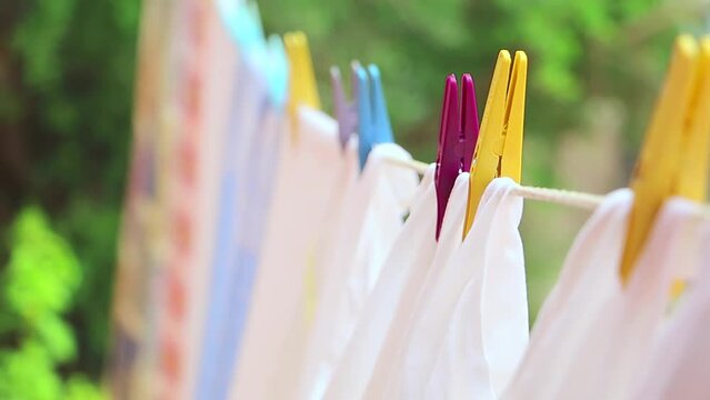 Drying laundry on the clothesline close up. Clean laundry hanging on a clothesline. Clean washed laundry hooked with clothespin hanging to the on clothesline
