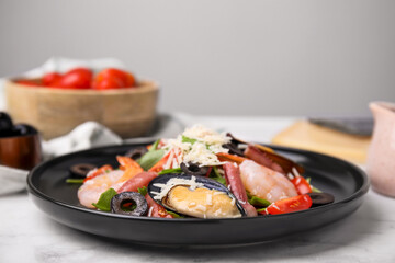 Plate of delicious salad with seafood on white marble table