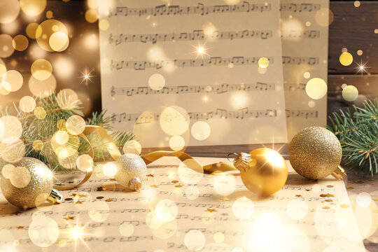 Composition with Christmas decorations and music sheets on table. Bokeh effect