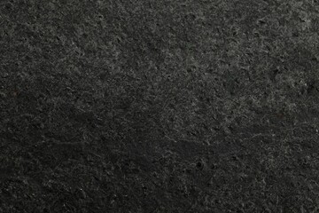Texture of dark grey stone surface as background, closeup