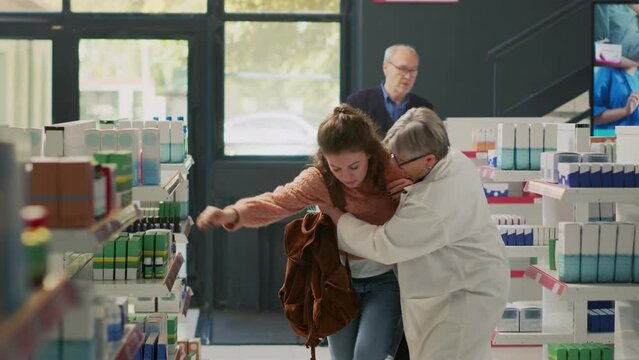 Young adult with spinning sensation and dizziness losing balance in pharmacy shop, almost fainting at drugstore. Woman feeling off and dizzy, losing consciousness and falling down. Dutch angle.