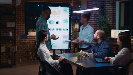 African american employees presenting company revenue statistics visualization in business meeting, people listening to presentation. Office workers in coworking space boardroom - Powered by Adobe