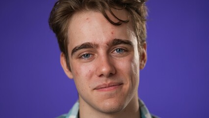 Closeup portrait of smiling happy young hipster man 20s isolated on solid purple background with copy space in studio