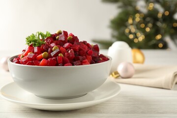 Traditional Russian salad vinaigrette on white wooden table