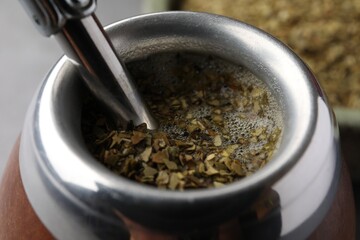 Calabash with bombilla and mate tea on table, closeup
