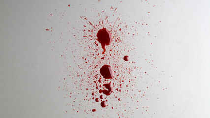 Stain and splashes of blood on light grey background, top view