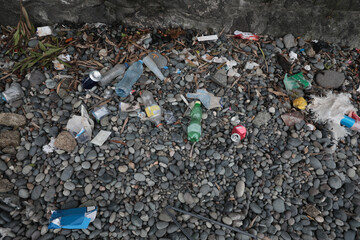 Garbage scattered on pebbles outdoors. Recycling problem
