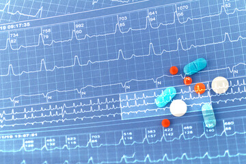 Electrocardiogram and pills merged in a double exposure.
