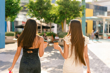 Women with takeaway coffee after shopping on street