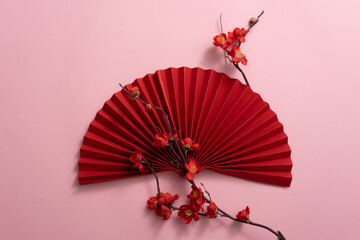 Chinese Lunar new year decoration with red paper fan and blossom on pink background. Japanese style. New year Decoration wall.