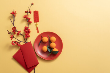 Chinese new year holiday background decorated with tangerines, red apricot blossom branches, and lucky envelopes. Copy space, Asia traditional holiday. 