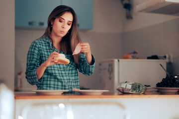 Woman Making a Sandwich for Breakfast in the Kitchen. Girl trying to make a fast meal with leftover ingredients
