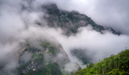 Panorama of the beautiful Scenery of Lush Green Mountains at Tiger Leaping Gorge in the clouds in the early morning after the rain