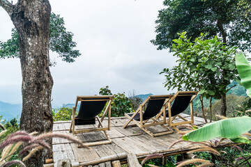 chair on balcony with mountain hill and foggy background