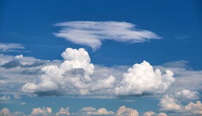 Bright landscape of white puffy cumulus clouds on blue clear sky