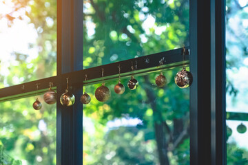 Golden glitter Christmas balls hanging for decorations on background window.Stylish christmas...