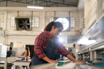 A furniture workshop making bespoke contemporary furniture pieces using traditional skills in modern design. A man in ear defenders holding wood, using a machine.