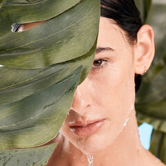 Woman, skincare and jungle leaves by face with water drop, moisturizer and wellness with mystery....
