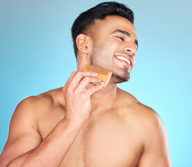 Beauty, brush and man comb beard for facial hair care maintenance, self care grooming or daily wellness treatment. Spa salon, healthcare and model with combing product isolated on blue background