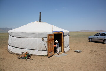 A boy with his ball in the nomadic tent of the lonely Atar steppe, Tuv region in Mongolia. The...