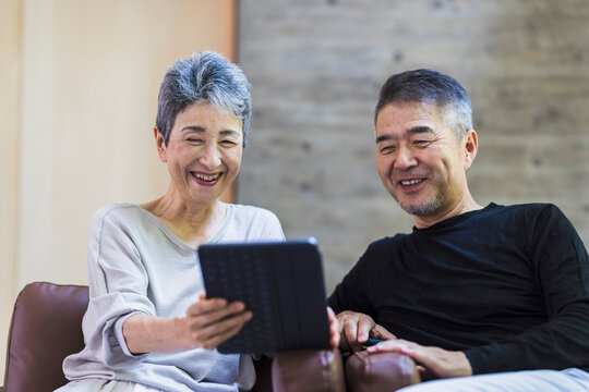 タブレットPCを見る日本人シニア夫婦