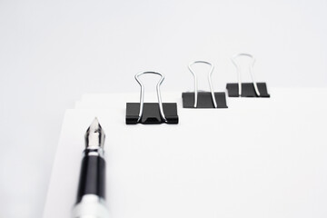 Pen on the stack of documents with paper clip folder
