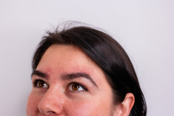 Obraz premium Brunette girl with short hair cut smiling after face and eyebrows procedure gray background