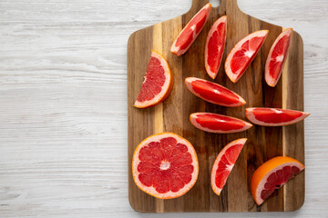 Organic Red Ruby Grapefruit on a Wooden Board, top view. Overhead, from above, flat lay. Copy space.
