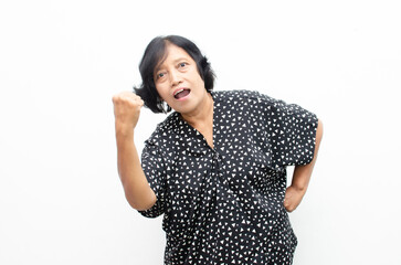 Portrait of happy ecstatic senior asian woman making yes winning gesture with raising her fist isolated over white