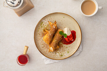 Portion of sweet crepe bliny roll with cream and jam
