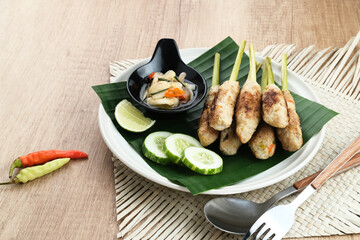 Sate Lilit, traditional Balinese minced chicken satay with lemongrass as skewer, served with sambal matah.
