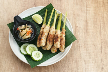 Sate Lilit, traditional Balinese minced chicken satay with lemongrass as skewer, served with sambal...