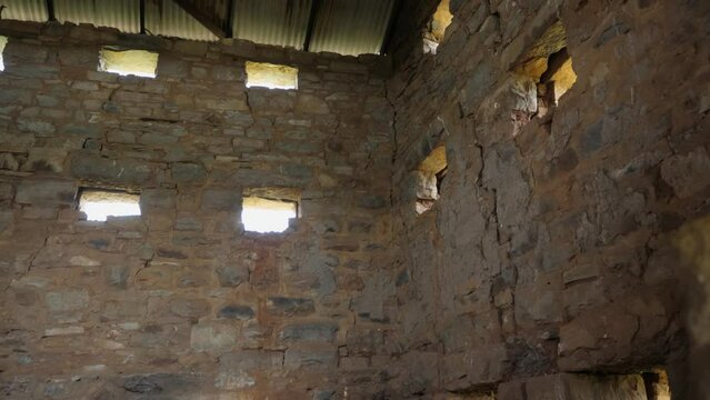 POV peering into loophole gun placements in old stone blockhouse