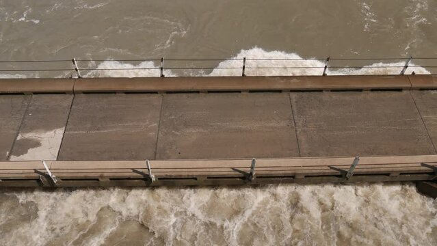 High angle view: Flooding river water reaches deck of one lane bridge