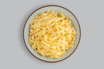 Plate with boiled noodles top view on a light gray background