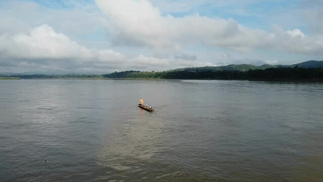 Fisherman's boat in the middle of the Mekong River, The boundary between Thailand and Laos. Aerial footage by drone.