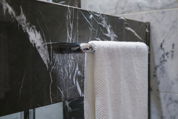 Modern design black and white marble bathroom with sink, whirlpool bath tub, shower, towels and...