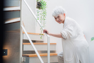 階段で腰痛に苦しむ高齢の女性